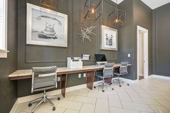 A room with a desk and chairs and a picture of a telephone on the wall.